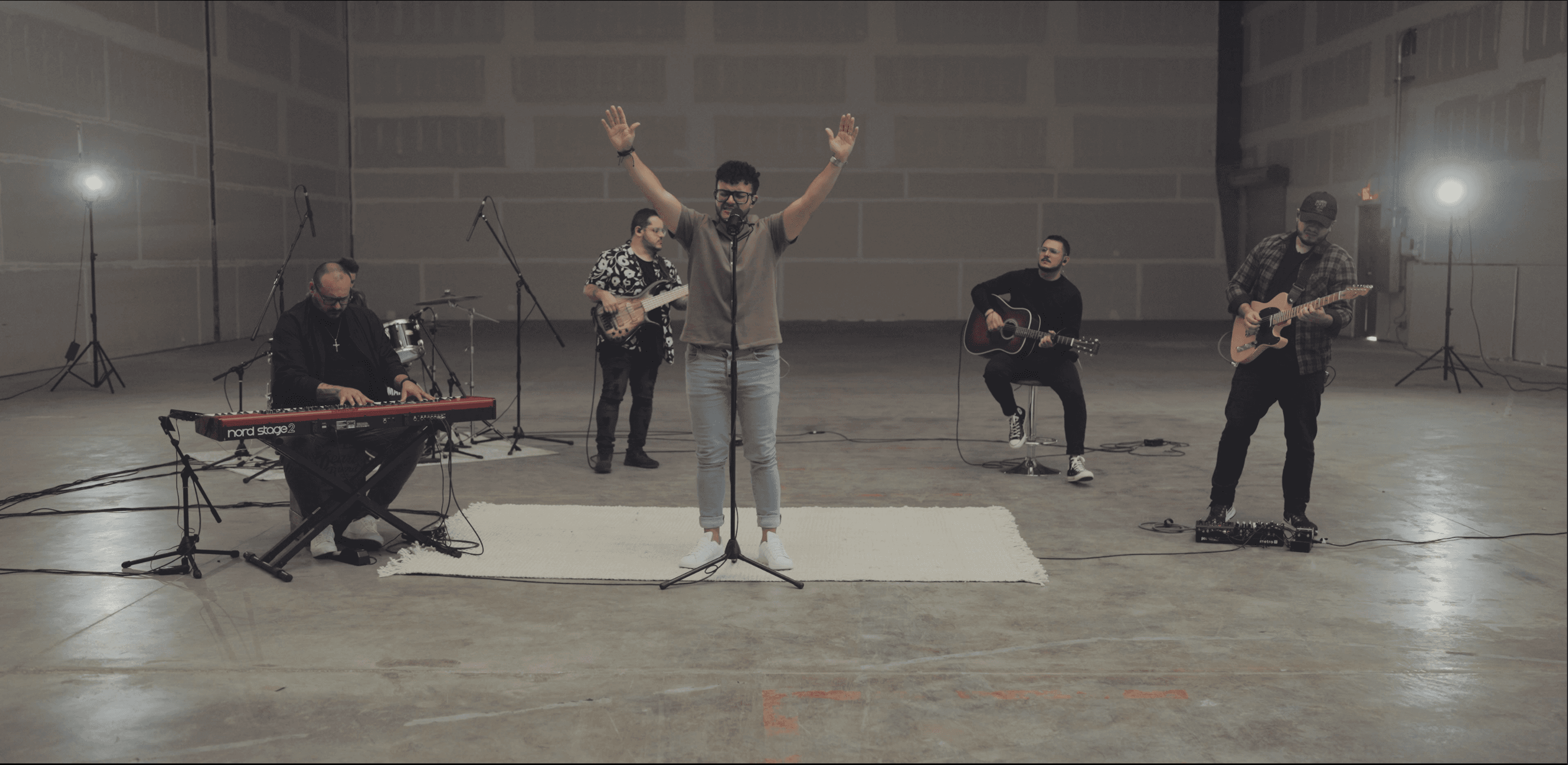 Músicos de PORVENIR en un espacio industrial, con el vocalista alzando las manos